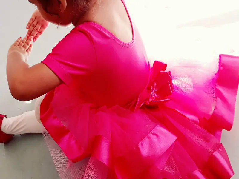 Detalhe de uma atividade de ballet na escola, com roupa de dança rosa