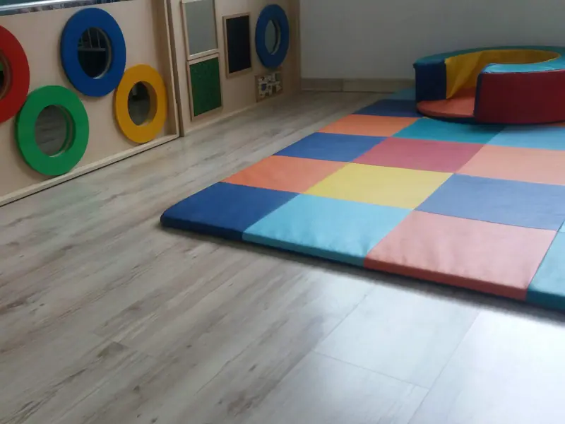Sala da escola com tatame colorido e espelhos na altura das crianças